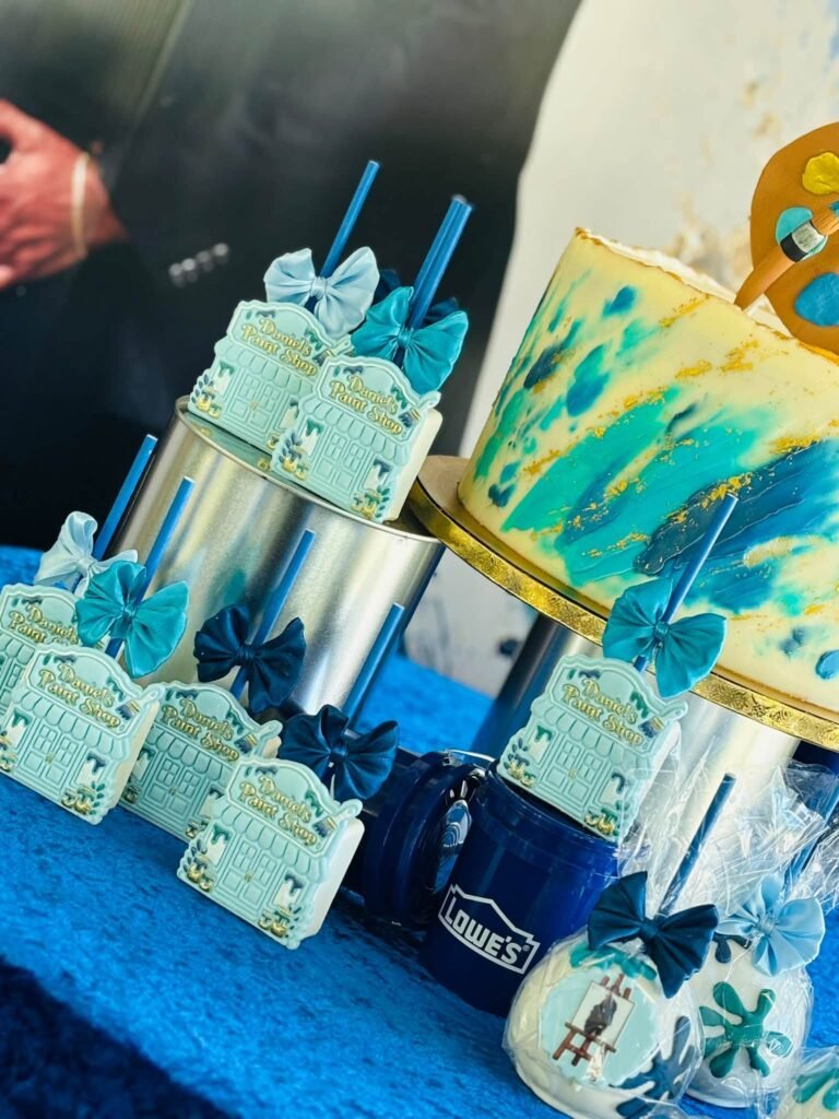 Brush stroke baby shower cake with teal and navy paint and favor boxes with bows