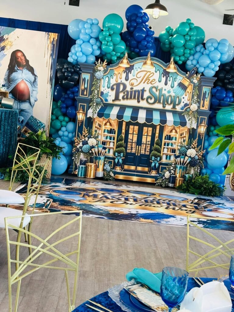 Paint Shop backdrop with balloons and a maternity photo banner in an event hall