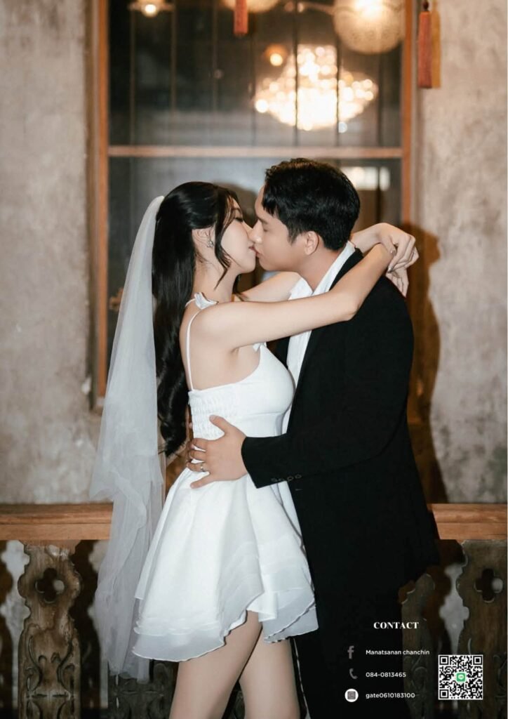 Groom kissing the bride in a short white dress and veil in a vintage room