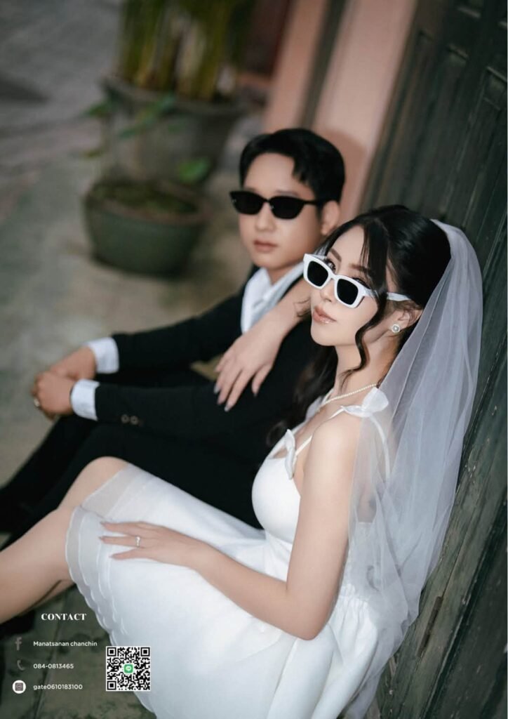 Bride in a short veil and white sunglasses leaning on the groom on wood steps