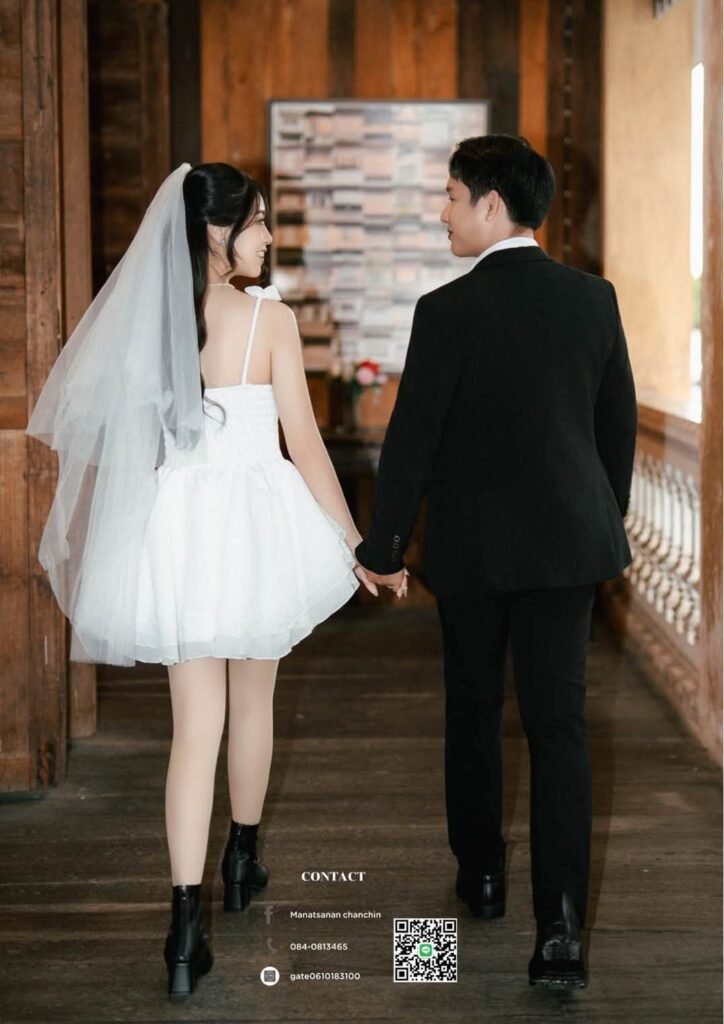 Back view of a couple walking through a wood hallway, bride in a strapless bubble mini dress