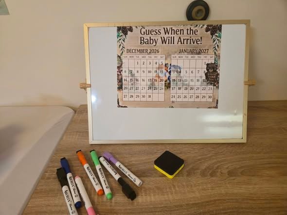Guess when the baby will arrive calendar board on a whiteboard with colored markers