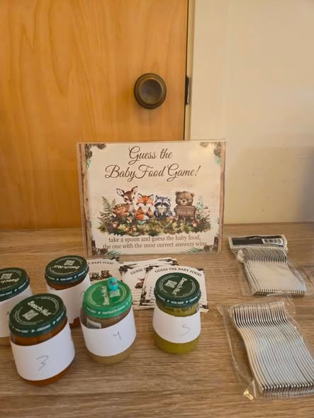 Guess the baby food game with numbered baby food jars, a woodland sign, spoons and cards