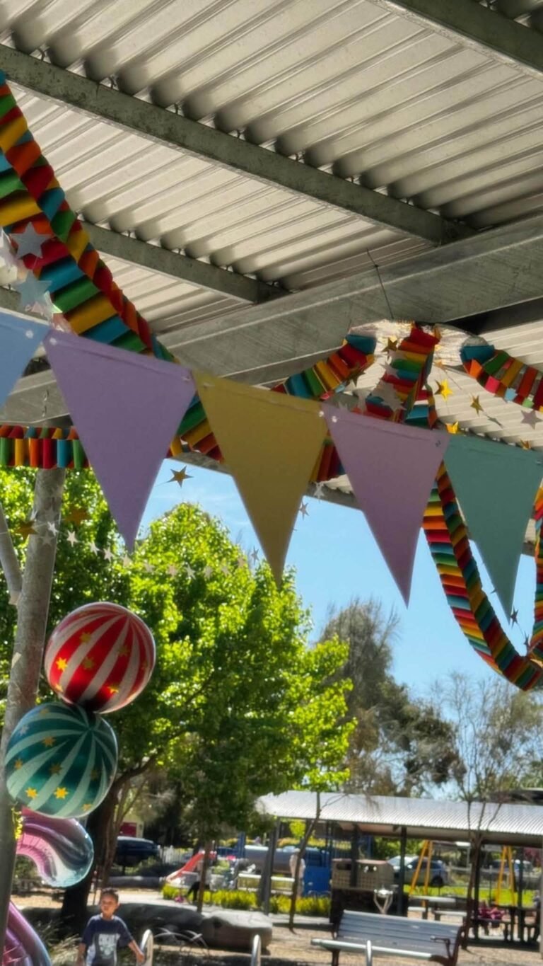 Rainbow pennant bunting hanging in a park shelter