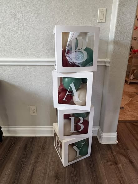 Clear BABY blocks stacked in the corner of a living room
