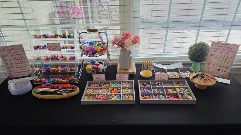 Long black table with bead trays and flowers