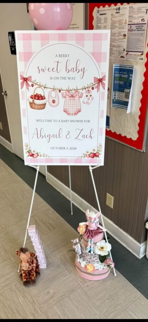 Berry sweet baby welcome sign with strawberries on an easel