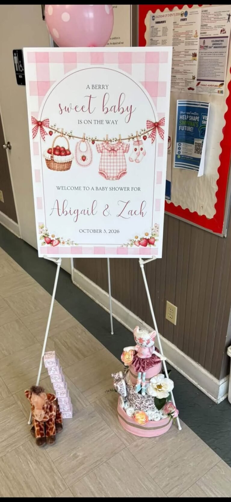 Berry sweet baby welcome sign with strawberries on an easel