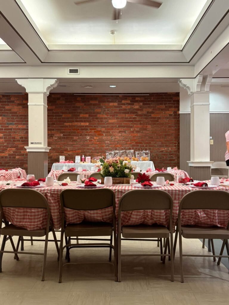 Pink baby shower tables with chair covers and flower centerpieces