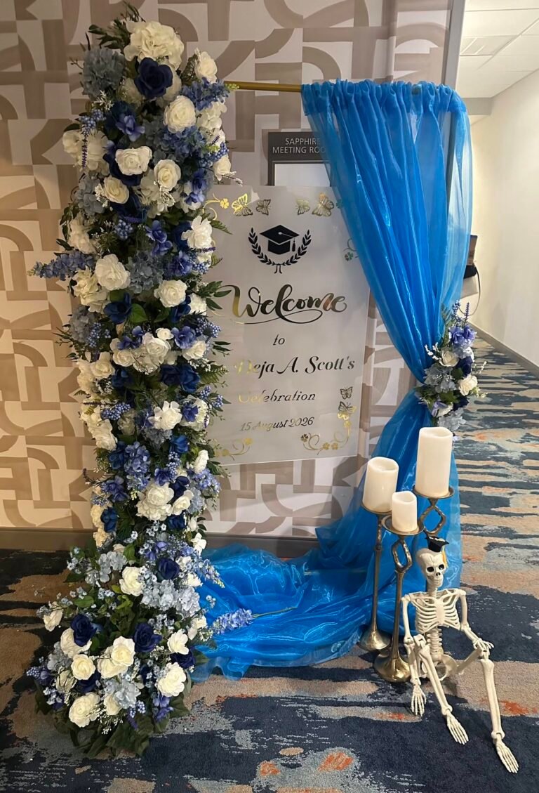 Blue and white flower column with a graduation welcome sign and blue drape