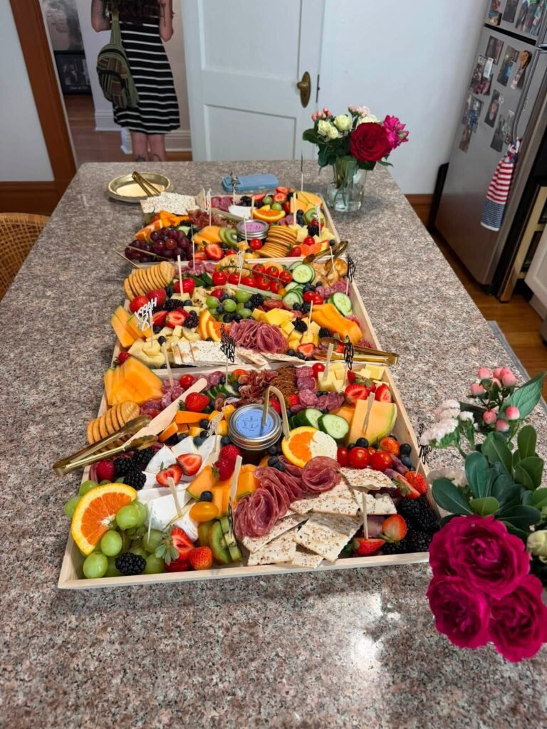 Long graduation grazing table with fruit, meats, cheese and roses