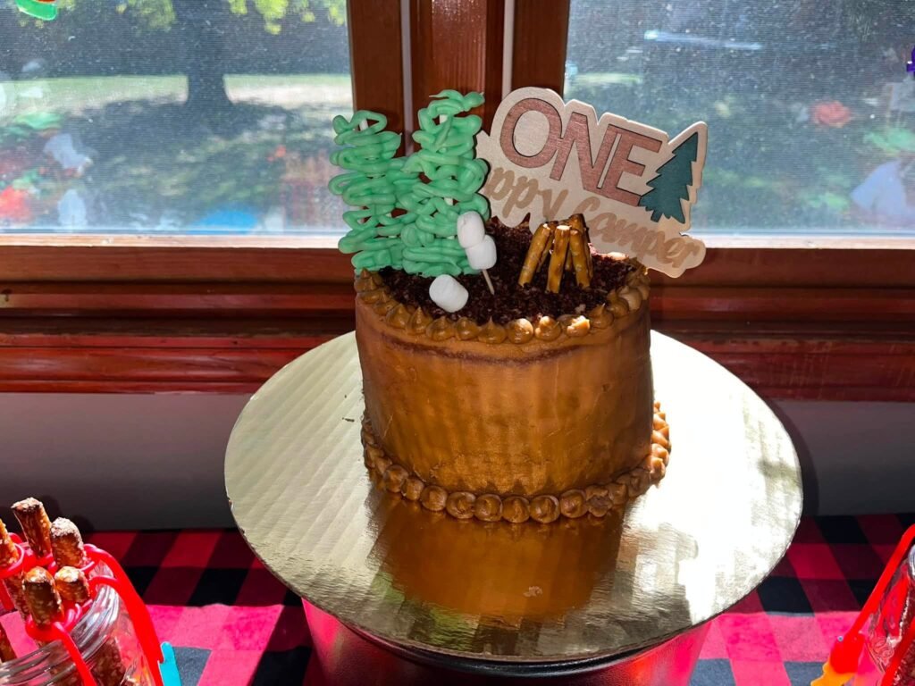 Gold cake with pine trees and a ONE topper