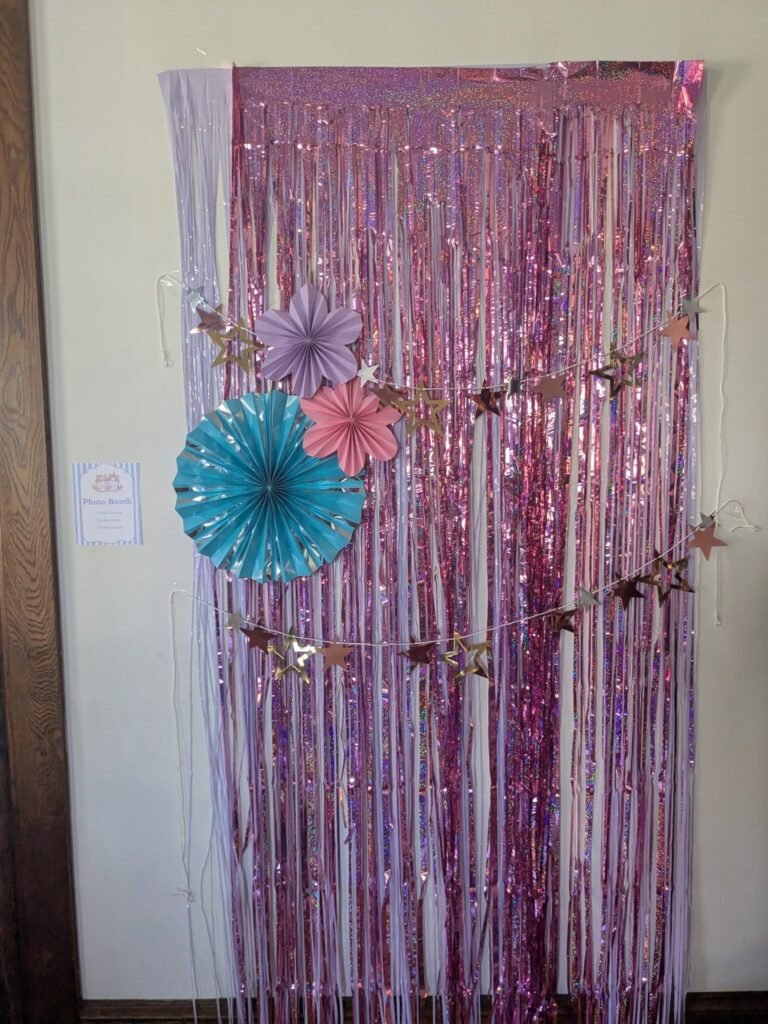 Pink tinsel door curtain with paper fans and flowers