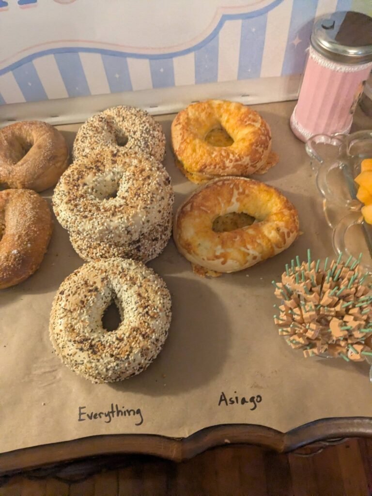 Close up of everything and plain bagels on brown paper with labels