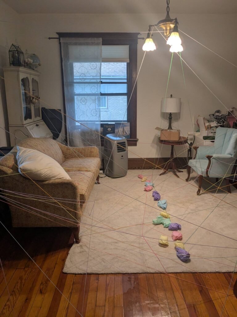 Living room with a trail of pastel cutouts across the rug