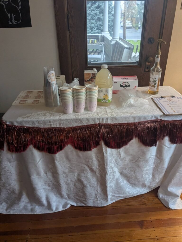 Drink table with a white cloth, a red ruffle edge and cups