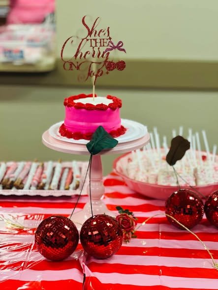 Pink baby shower cake with a cherry on top topper and red cherry decor
