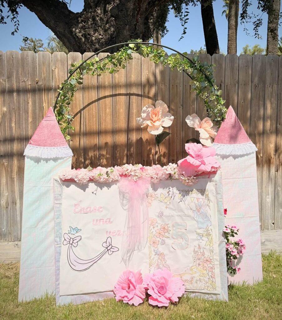 Cinderella castle backdrop in white and pink with a floral hoop and pink flowers
