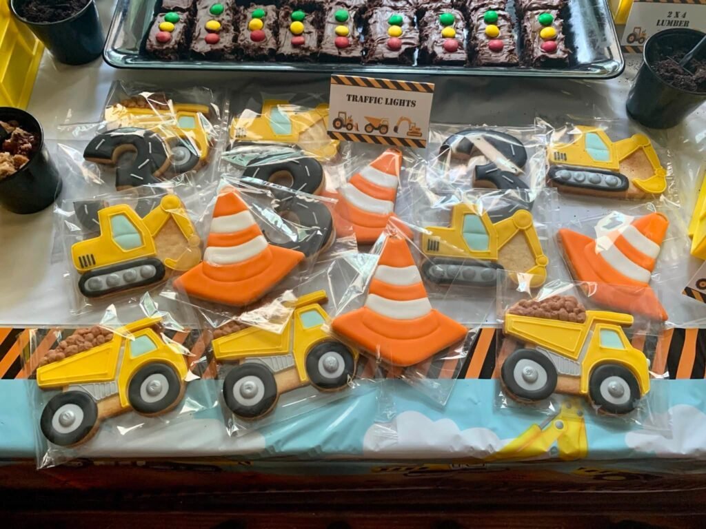 Traffic cone and dump truck sugar cookies on a construction tablecloth