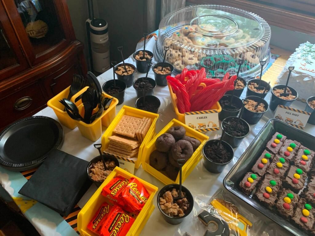 Construction snack table with yellow bins of candy and chips