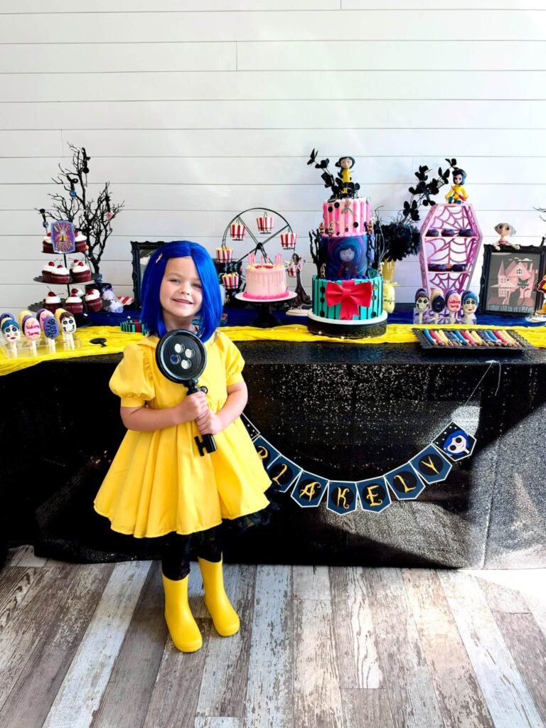 Little girl in a yellow raincoat by the Coraline dessert table
