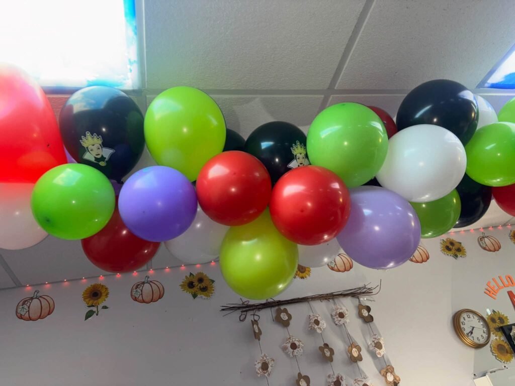 Purple, green, black and red balloon garland