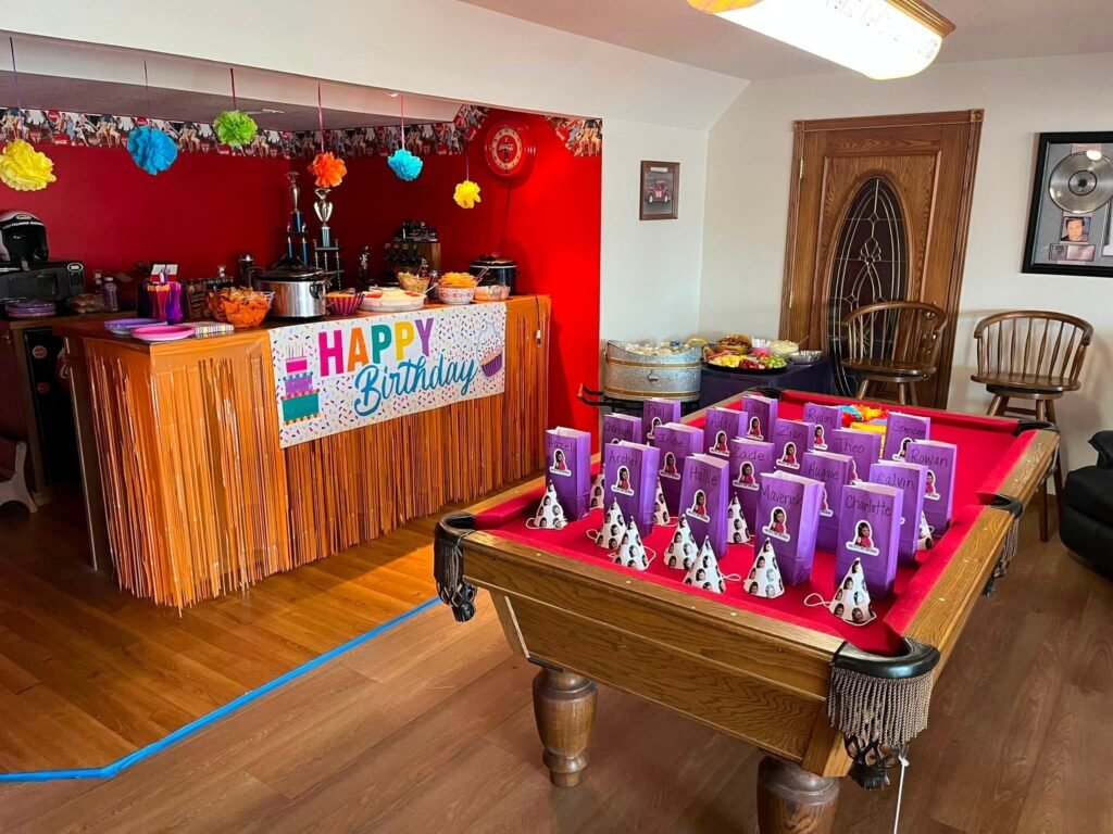 Game room with a fringe curtain banner and favor bags on a pool table