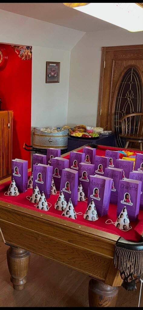 Purple favor bags lined up on a red table