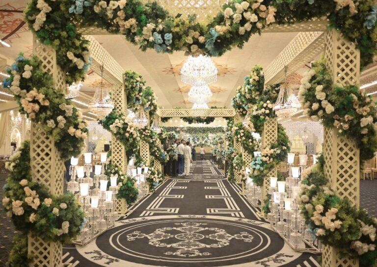 Flower lined walkway with chandeliers leading to the wedding stage