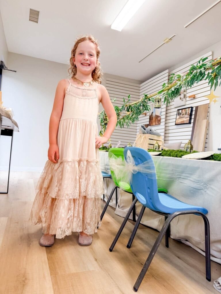 Birthday girl in a cream ruffle dress at her party