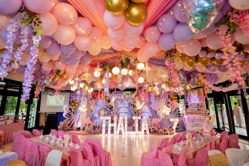 Balloon and hanging flower ceiling over pink party tables