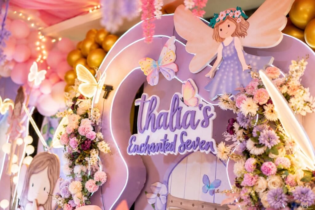 Enchanted Seven fairy stage with a name sign, butterflies and lilac balloons