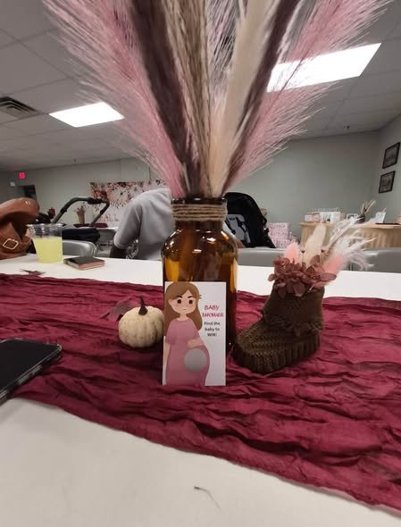 Burgundy table runner with a white pumpkin, pampas and a bottle vase