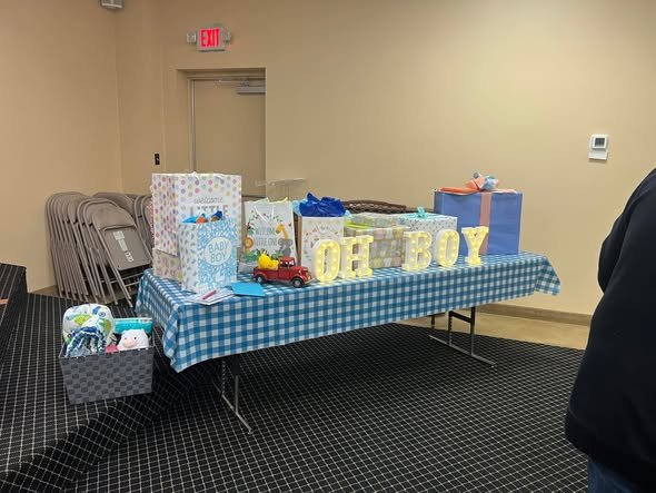 Oh Boy gift table with blue gingham and gift bags at a baby shower