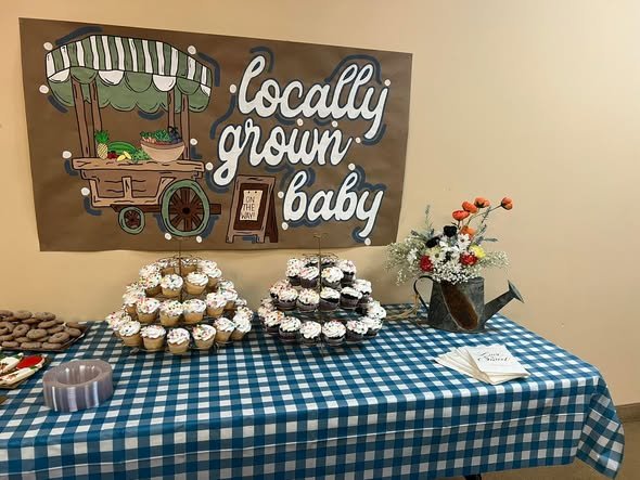 Locally Grown Baby sign over a cupcake tower on a blue gingham table