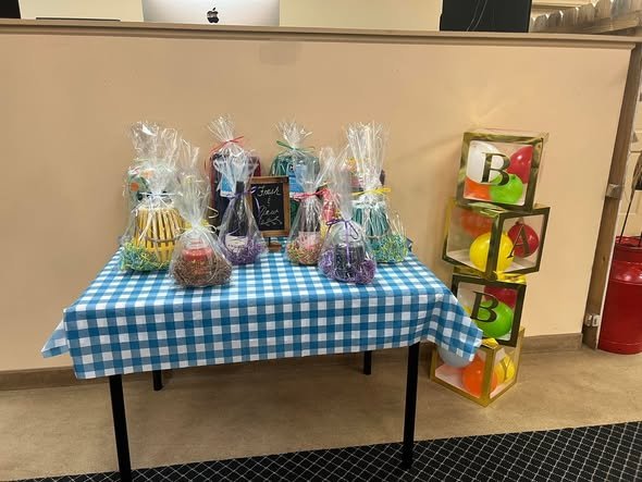 Baby shower favor table with wrapped treats and clear blocks on blue gingham