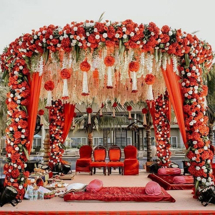 Red and orange floral mandap with hanging flower strands