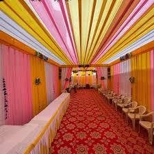 Pink, yellow and orange drape tunnel over a red carpet