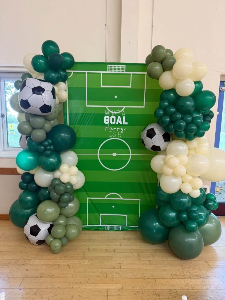 Soccer field backdrop with green, white and soccer ball balloons