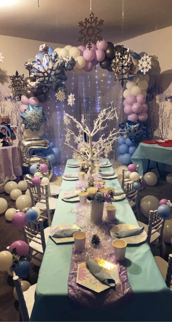 Frozen party room with balloon arches and long tables