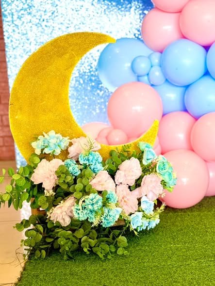 Gold moon with pink and blue balloons and pastel flowers at a gender reveal