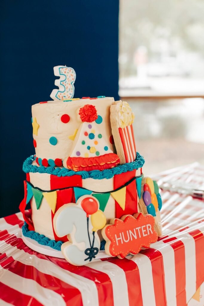 Three tier circus cake with popcorn, stars and a number three