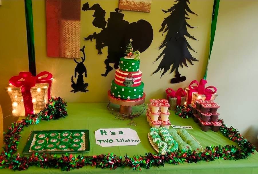 Grinch food table with a small Christmas tree and green decor