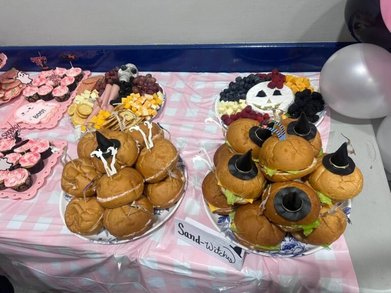 Sand-witches with tiny witch hats and a Sand-witches sign on a pink gingham table