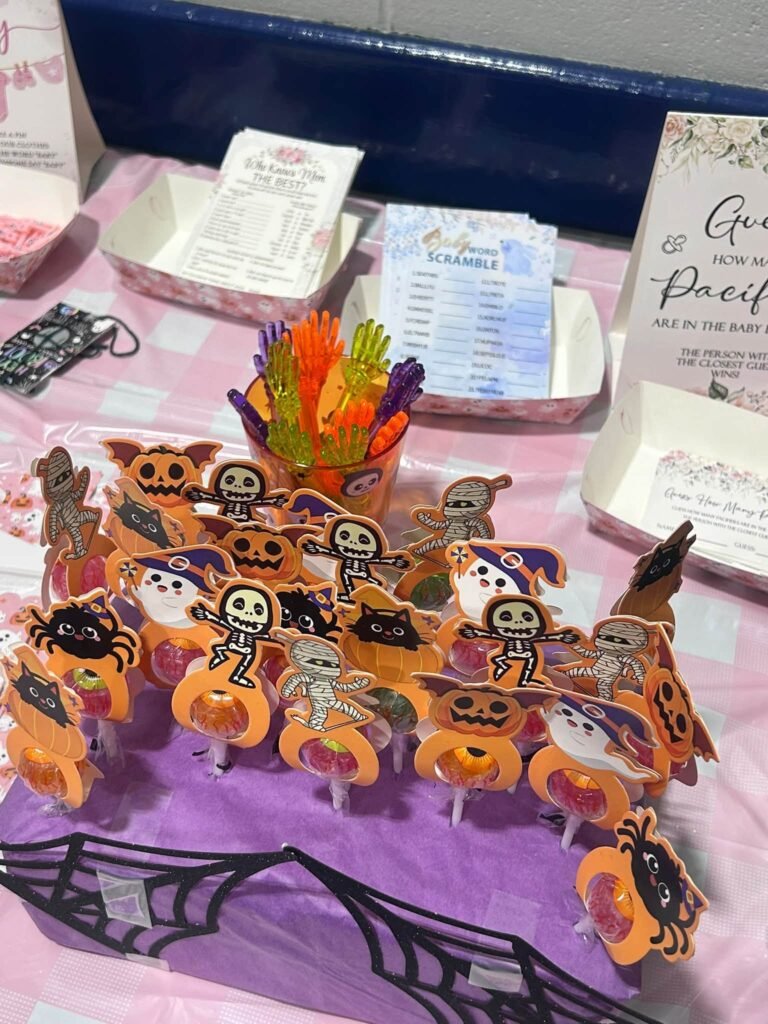 Pumpkin and skeleton cupcake toppers on a purple and black table