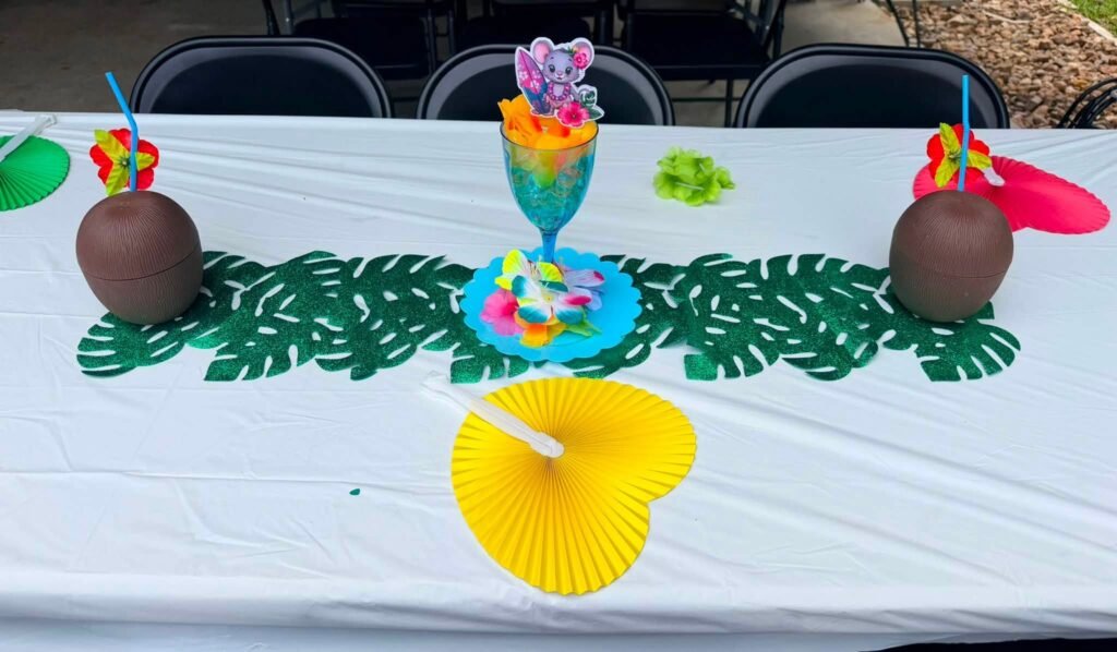 Coconut cups and a yellow paper fan on palm leaves