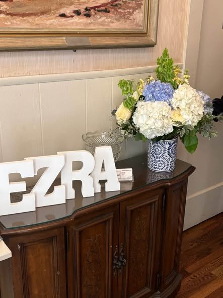 White letters with the baby name and blue and white hydrangeas on a dresser