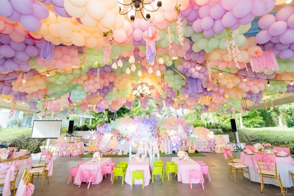 Pastel balloon ceiling over round tables in a party hall