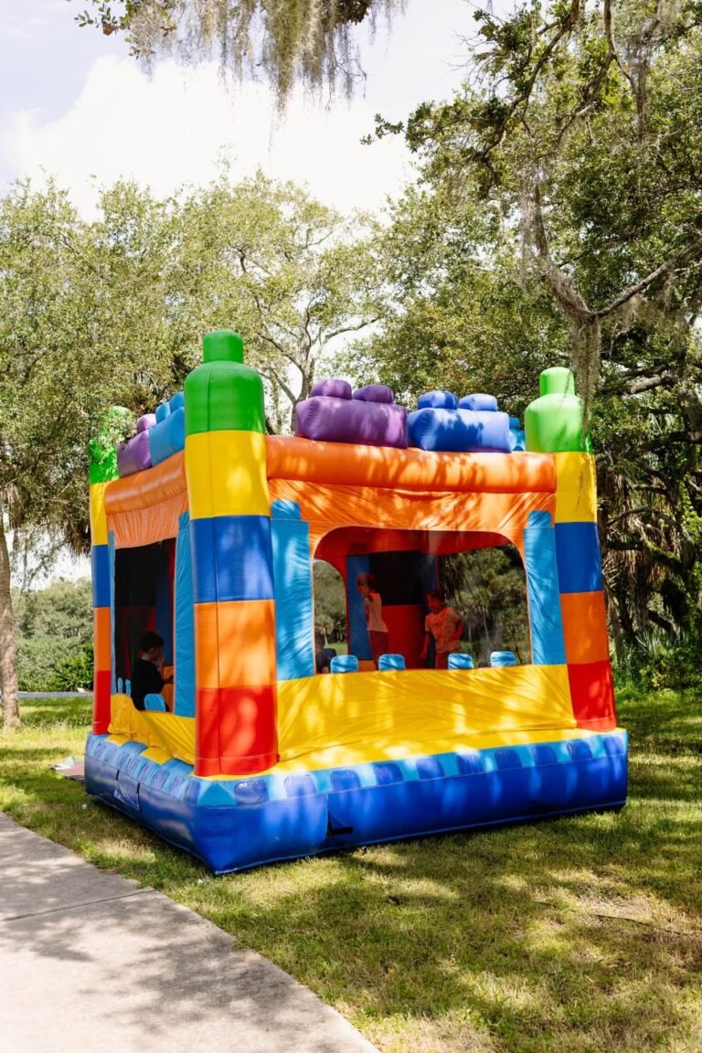 Rainbow block bounce house on the grass at a park