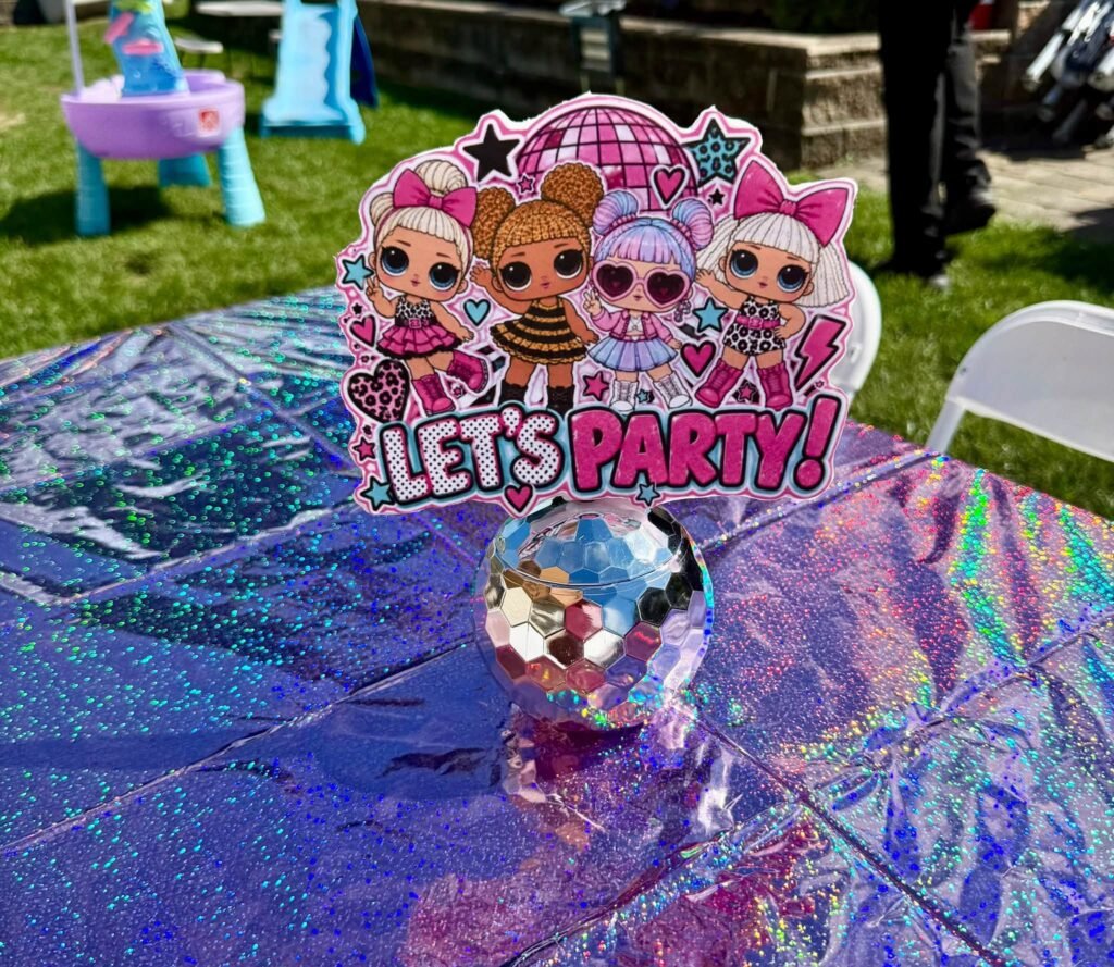 Disco ball centerpiece with a Let's Party topper on a shiny table